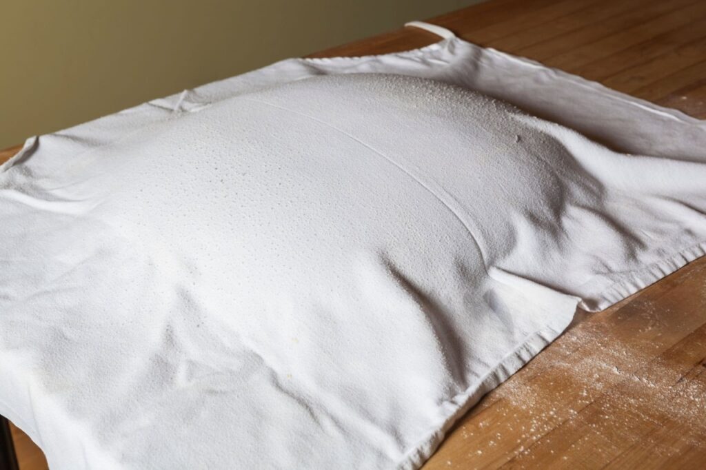 Pillowcase soaking in baking soda and vinegar solution for stain removal