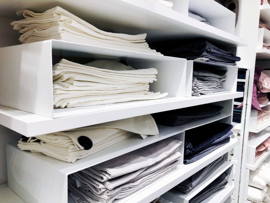 Organized linen closet with vertically stored sheets