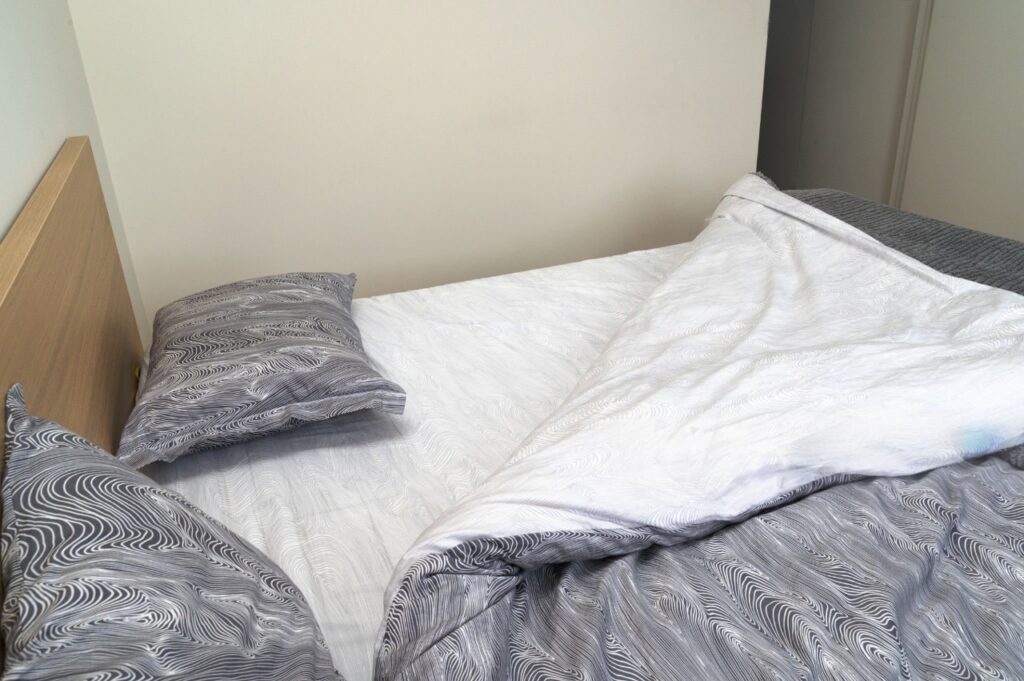 Duvet cover folded neatly next to shrunken comforter