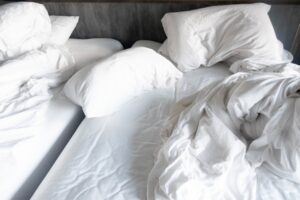 Side-by-side of messy, sweaty bed vs. perfectly made bed with crisp sheets - "Before & After My Sheet Revolution