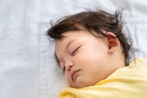 Baby sleeping soundly on non-toxic organic cotton crib sheets