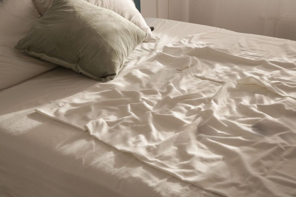 Silky bamboo sheets draped elegantly on bed vs. close-up of pilling after 3 weeks